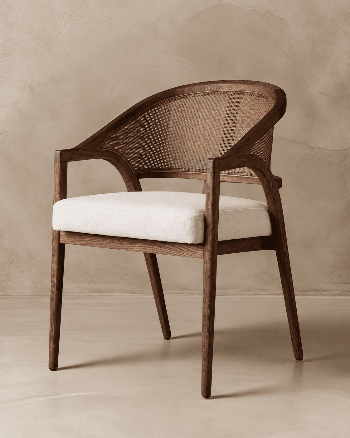 ARCEL premium cane dining armchair with sculptural wooden frame, natural cane backrest and upholstered seat in a neutral interior setting.