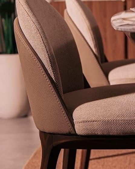 ELORA premium upholstered dining chair showing its rounded padded back, textured brown upholstery and dark wooden frame in close-up.