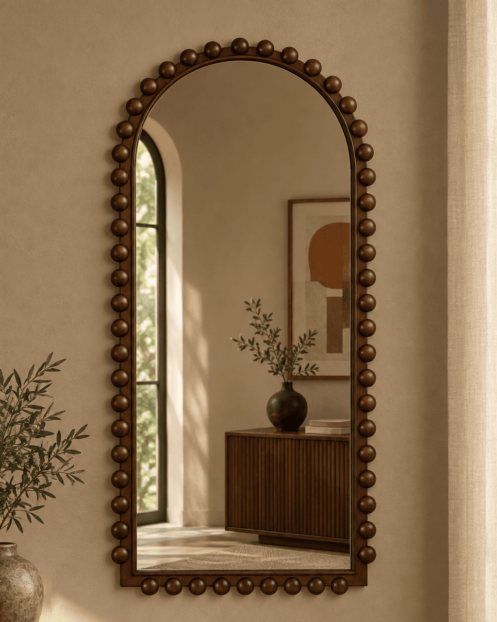 PERLE arched wooden wall mirror with rounded bead detailing in a warm interior.