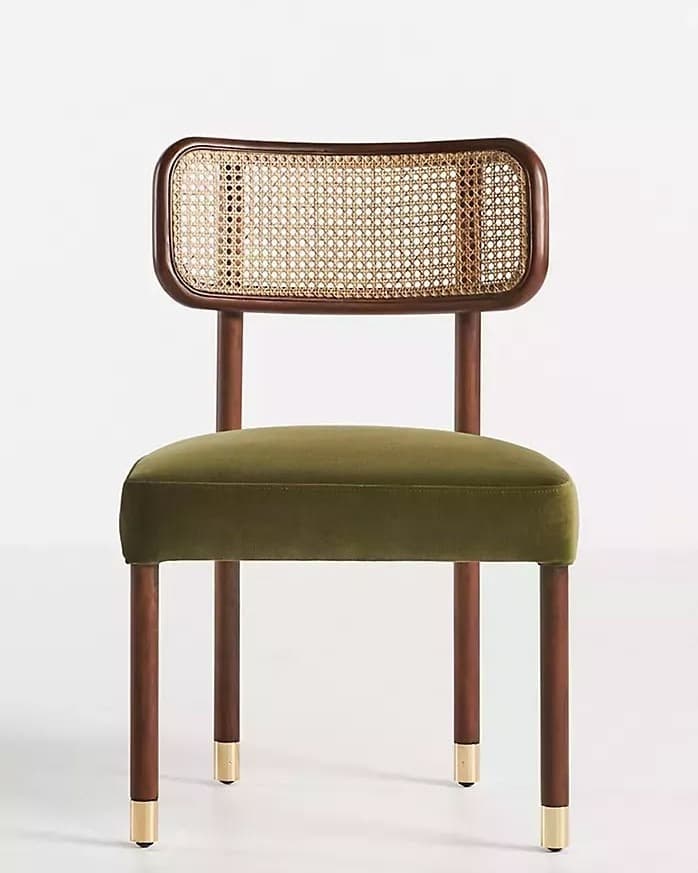 LÉNA premium dining chair with rounded natural cane backrest, olive-green upholstered seat, walnut wooden frame and brass-gold foot caps.