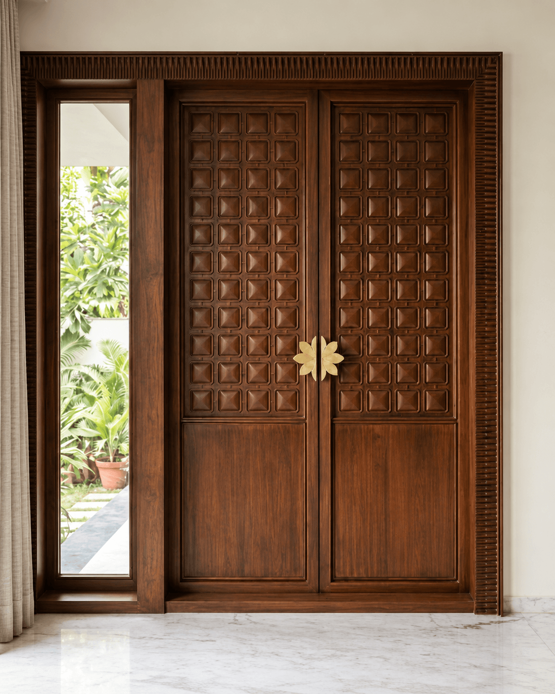 Classic Grid Double Main Door installed in a premium residential interior, featuring rich wooden panels, raised square detailing, side glazing and a decorative floral centre pull.