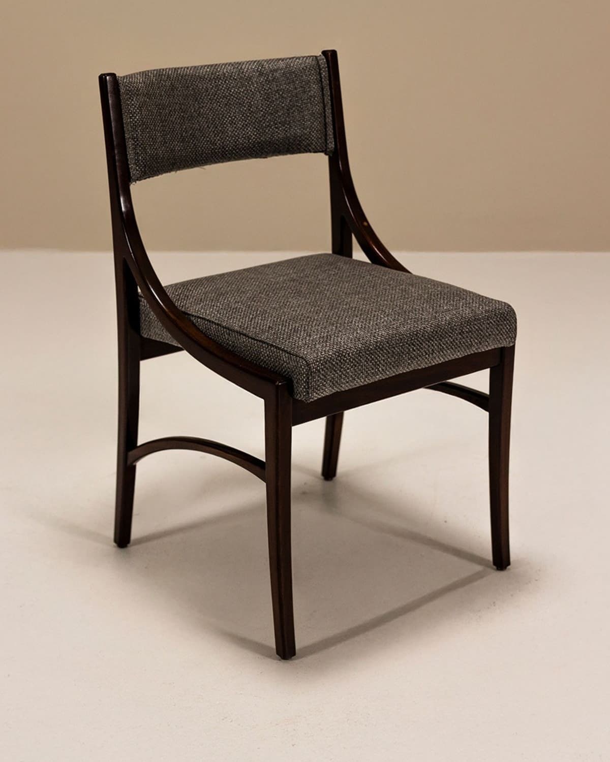 ATKIS premium dining chair with dark walnut wooden frame, grey upholstered seat and structured back in an elegant interior setting.