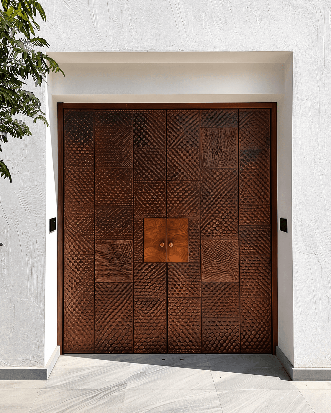 Artisan Textured Panel Double Main Door installed at a luxury exterior entrance, featuring varied carved wood-texture panels and a warm central wooden detail.