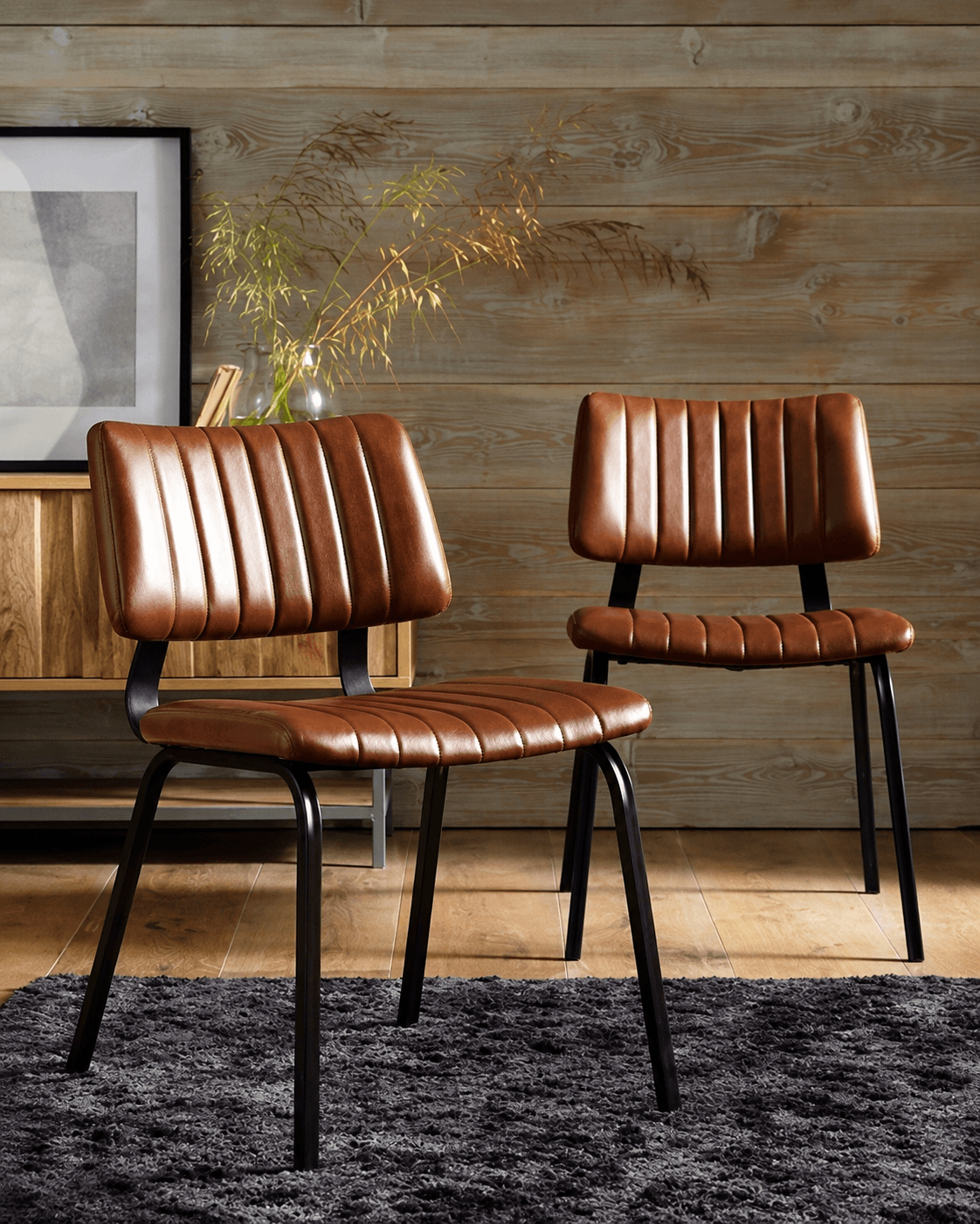 BRUNE channel-tufted dining chair in tan-brown upholstery with a slim black metal frame in a stylish interior.